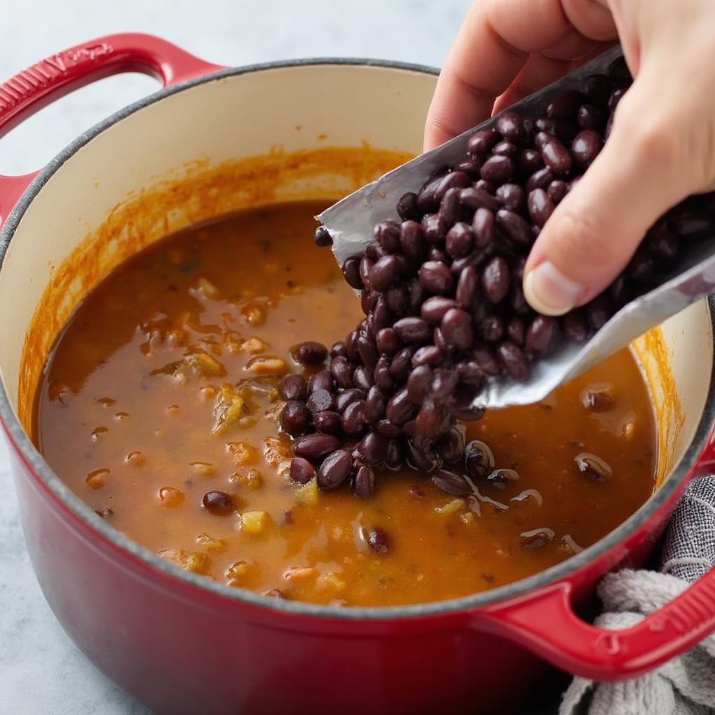 Adding frozen black beans to a pot of soup