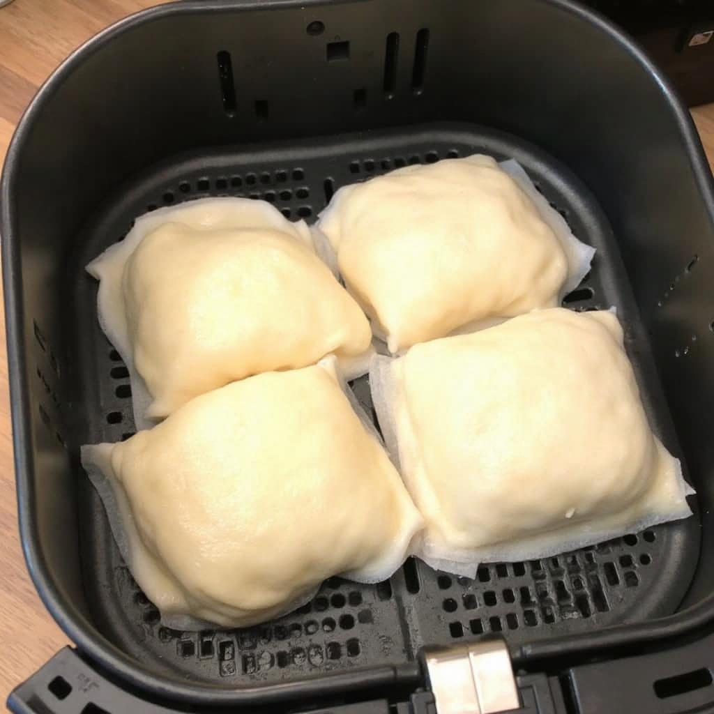 Frozen lumpia cooking in an air fryer